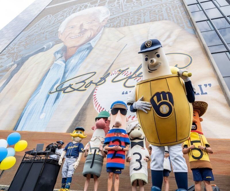 The Brewers Barrelman mascot along with the Famous Racing Sausages are seen at a tailgate-themed celebration marking the completion of “Mr. Baseball,” a new 80-by-100-foot mural by artist Mauricio Ramirez depicting longtime Milwaukee Brewers broadcaster...