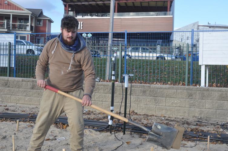 Ice Castle employee Joe Weiler does some digging work on Riviera Beach to prepare for the 30,000-square-foot ice structure