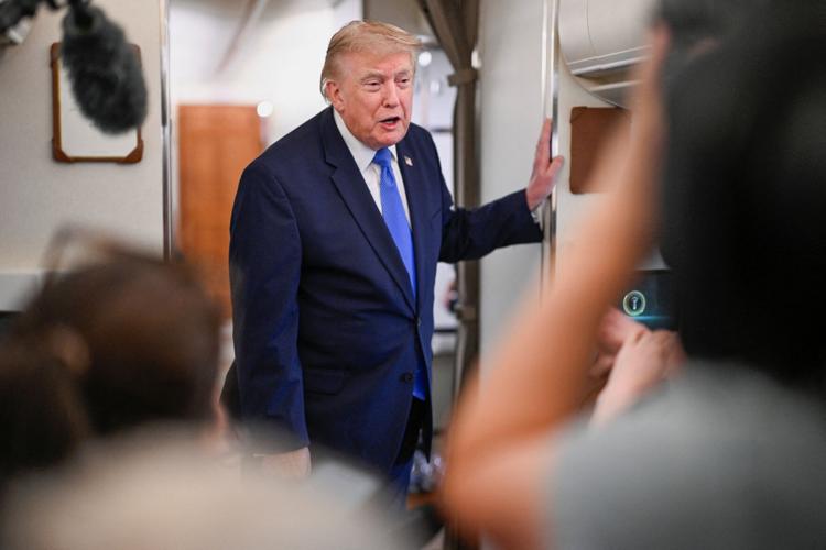 U.S. President Donald Trump speaks to the meadia aboard Air Force One