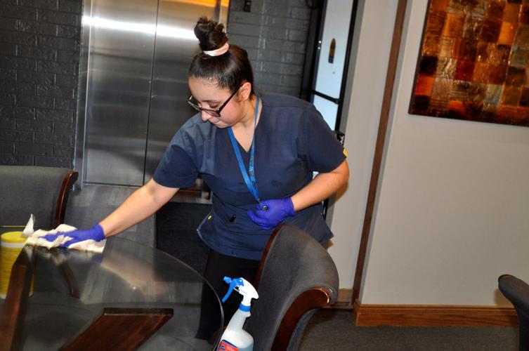 Vanessa Flores, Harbor Shores hotel employee, cleans a table in the lobby of the hotel