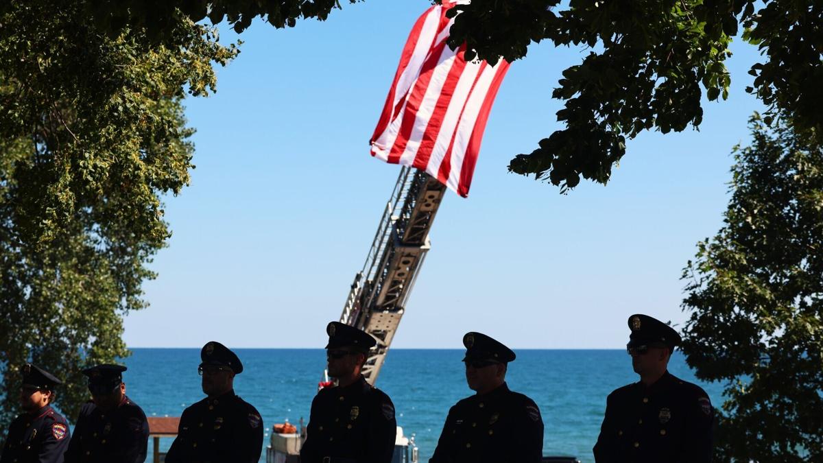 Kenosha Police Department Honor Guard members stand in front of American flag