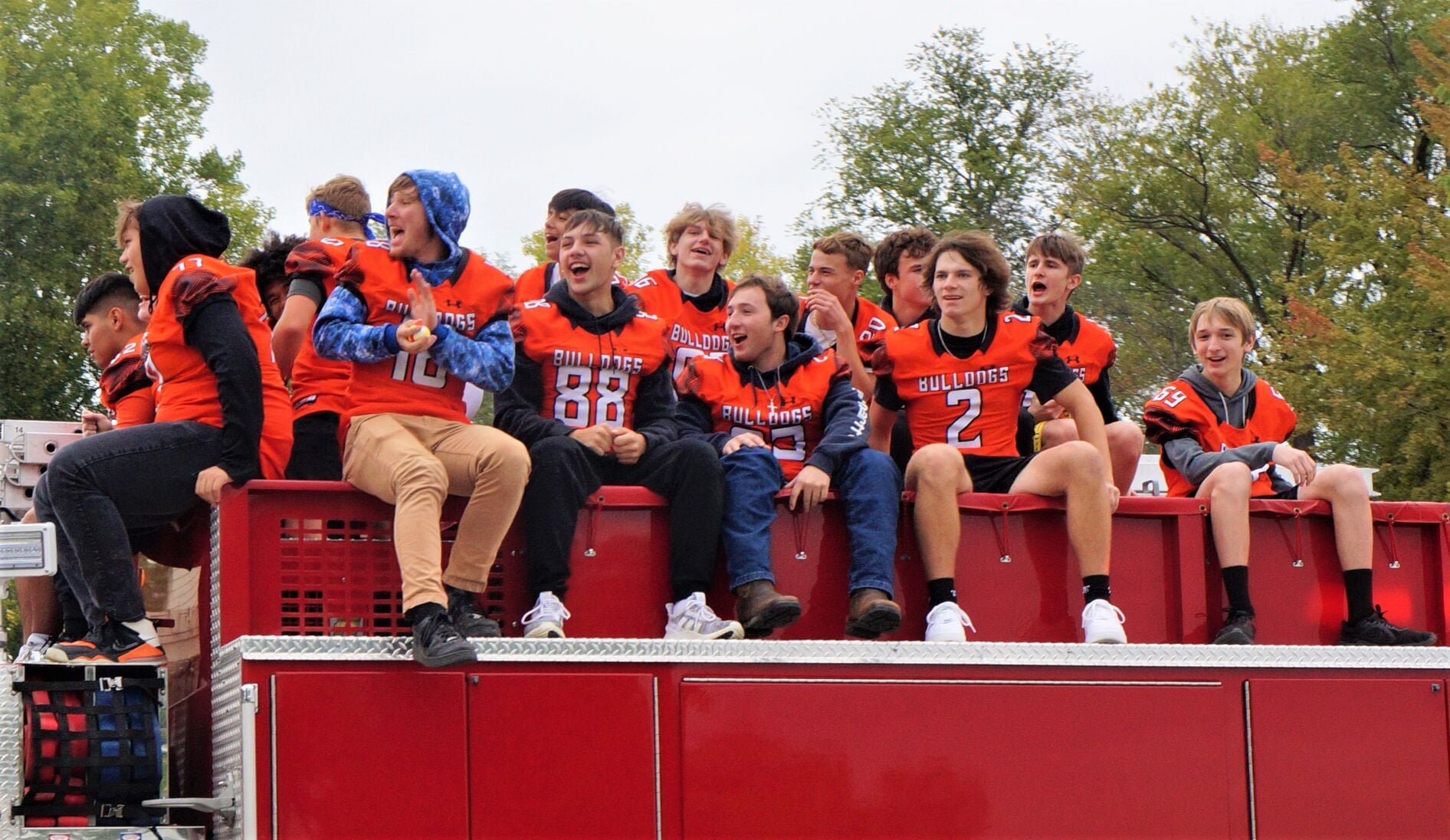 The Williams Bay High School Bulldogs football teams rides atop a fire engine in the 2022 homecoming parade