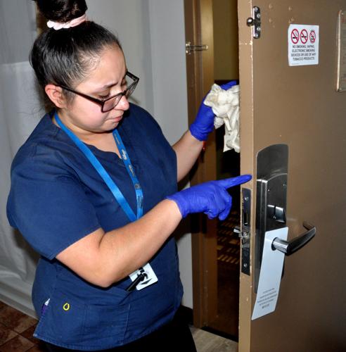 Vanessa Flores, Harbor Shores hotel, cleans down a door to a hotel room.