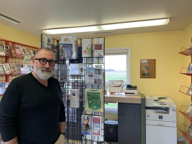 New Walworth County Visitors Bureau Director Tim Malenock stands next to some materials that the bureau uses to help promote tourism in the area
