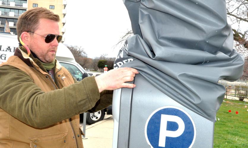 Seth Elder, parking operations manager, performs some maintenance to a parking kiosk