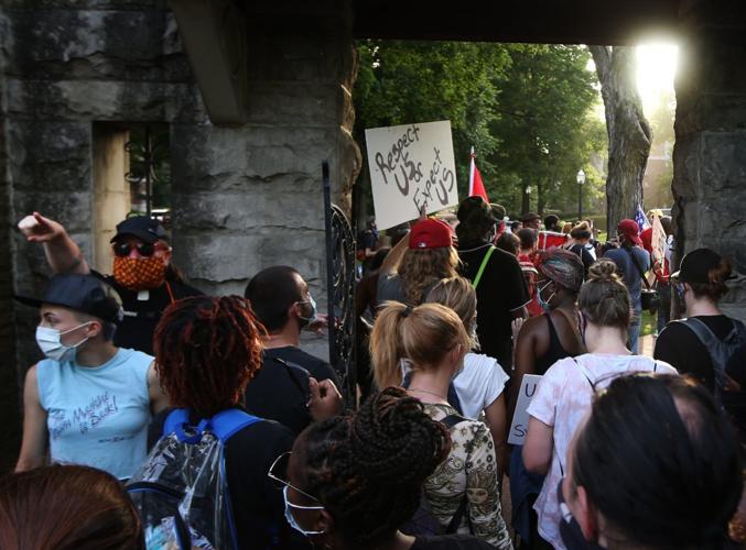 Protesters marching through pedestrian gate to private street