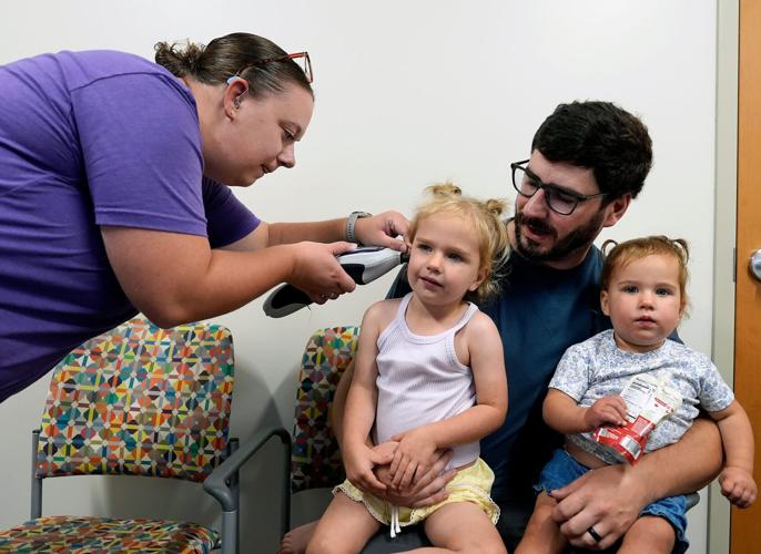 In July, the Plumb sisters became the first in the nation to receive a newly approved gene therapy called Otarmeni to treat a rare genetic form of hearing loss.Their father, Ty, holds the sisters as audiologist Dr. Olivia Riemer checks 2-year-old Cleo’s