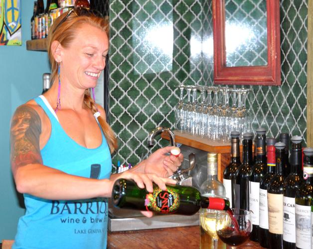 Dana Trilla, co-owner of Barrique Bistro & Wine Bar, pours glasses of wines for some customers