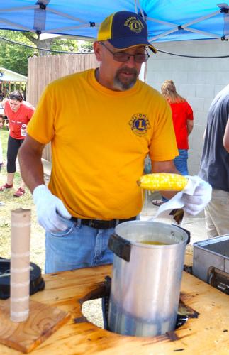 Sharon Lions Club Third Vice President Jerry Olsen dips buttered corn on the cob