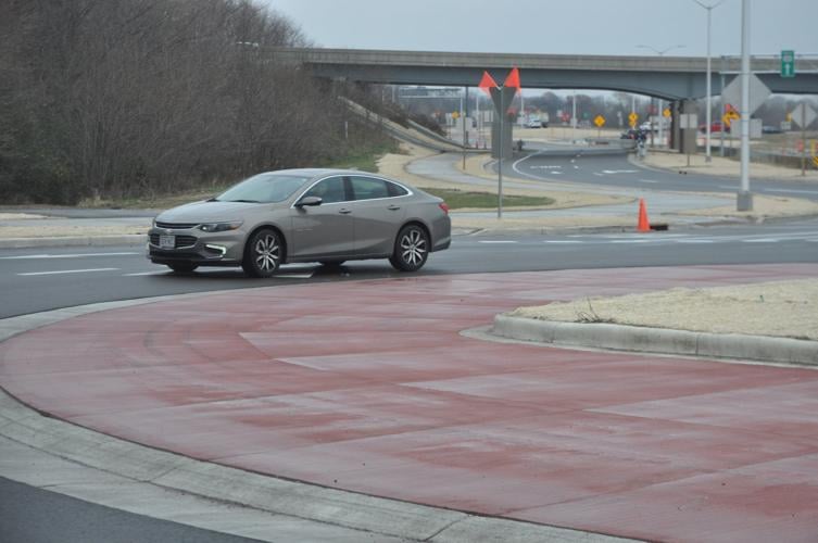 A car drives through a recently-completed roundabout on Highway 120