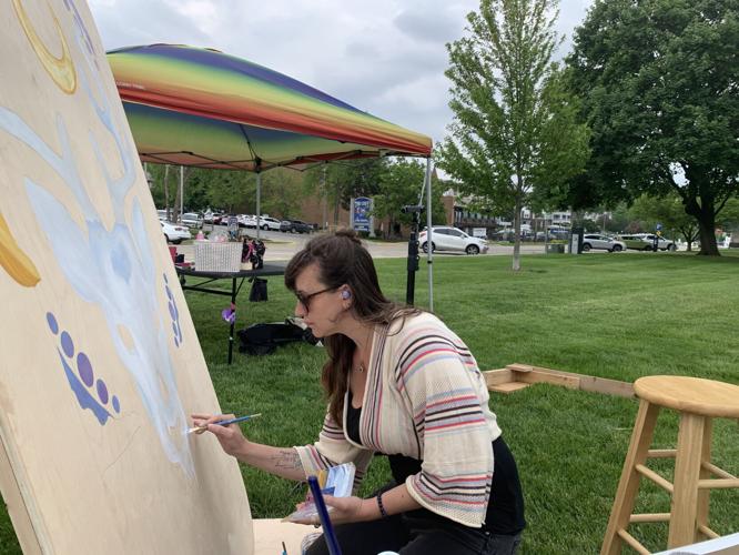Jennifer Schildgen works on a four-panel mural in Flat Iron Park