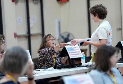 A poll worker assists a voter during the Aug. 11 partisan primary election at Shepherd of the Hills Lutheran Church in Greenville.