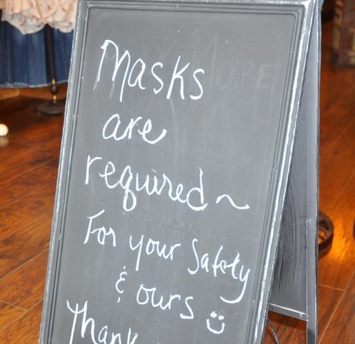 A sign posted near the Twelfth & Brown store requires customers to wear facemasks before entering
