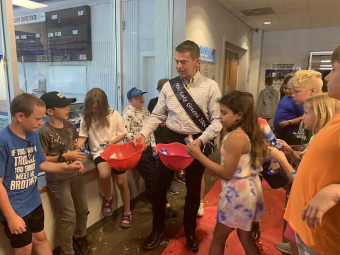 Mr. Lake Geneva Skip Harless passes out candy to children at the Geneva Lakes Family YMCA