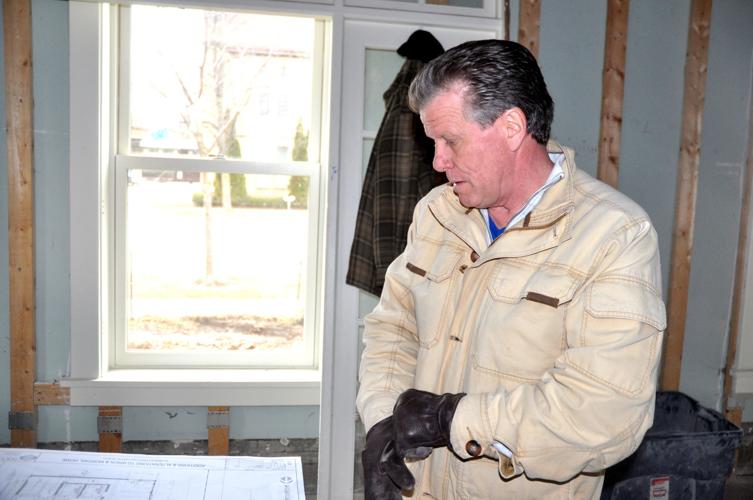 Charles Manusos, president and CEO of the Nikao Group, looks over some renderings