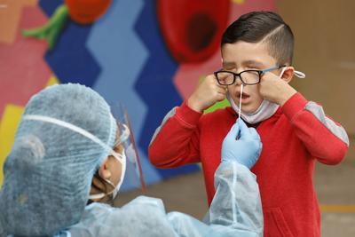 Kindergarten student Matteo Rodriguez gets a Covid-19 test from EMT Claire Chou on April 13, 2021, in Maywood, California..