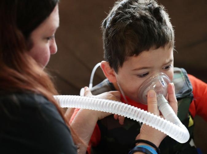 Amy giving breathing treatment to Javier