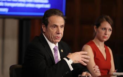 Andrew Cuomo and Melissa DeRosa at podium