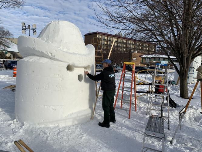 James Malkowski of Wisconsin team "Snow Cronies Too" drills some holes into the team's sculpture