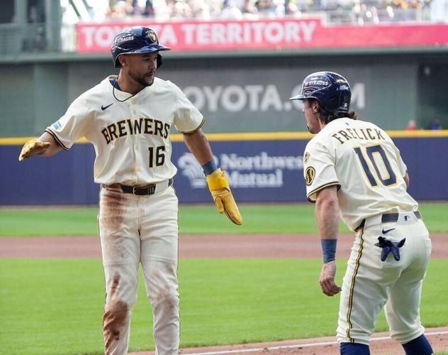 Milwaukee Brewers Blake Perkins and Sal Frelick celebrate scoring against the Chicago Cubs.