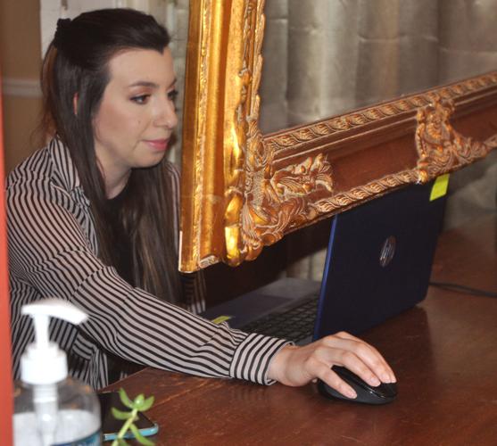 Emily Hobson, Maxwell Mansion employee, works behind the desk of the historic home