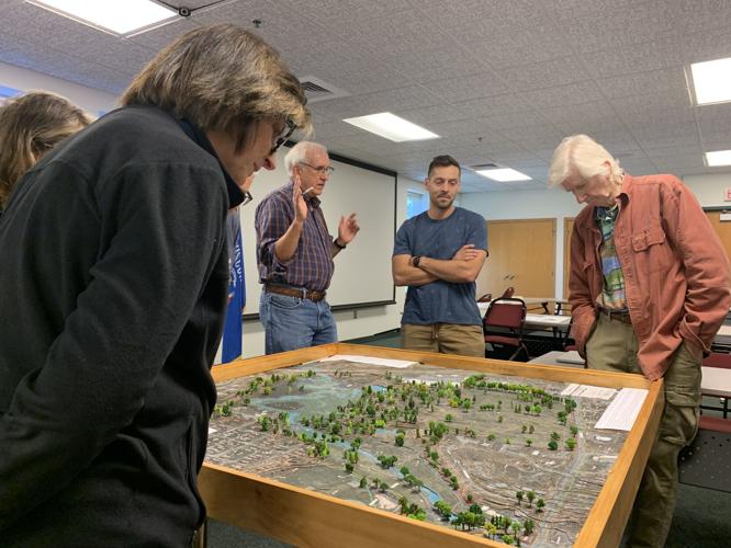 Residents and city officials look over a three-dimensional topographical map of the Hillmoor property