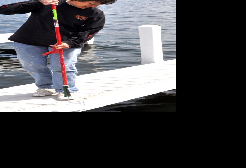 Harbormaster Linda Frame paints a section of the west end pier along Geneva Lake