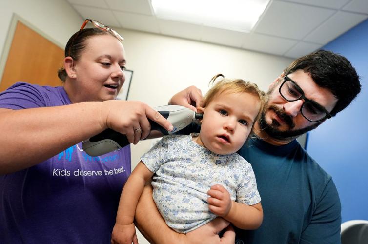 Ty Plumb holds his daughter Lennon, 19 months, as audiologist Dr. Olivia Riemer checks her ear canal Aug. 25 at Children’s Wisconsin Appleton Clinic in Appleton.