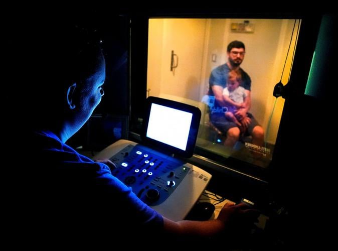 Ty Plumb holds his daughter Lennon, 19 months, during a hearing test run by audiologist Dr. Olivia Riemer on Aug. 25 at Children’s Wisconsin Appleton Clinic in Appleton.