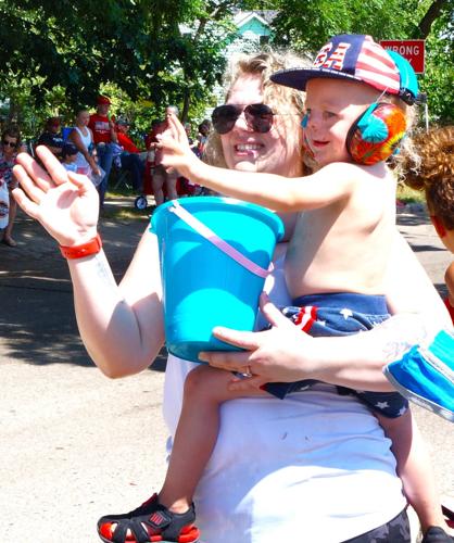 Hannah and Cayden White wave to participants in the Sharon Fourth of July parade