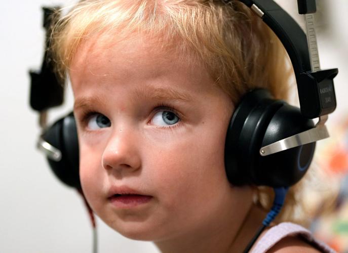 In July, the Plumb sisters became the first in the nation to receive a newly approved gene therapy called Otarmeni to treat a rare genetic form of hearing loss. Here, Cleo, age 2, reacts to a sound in her headphones during an Aug. 25 hearing test at Childr