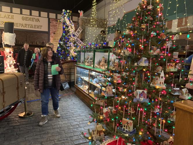 Participants and museum volunteers walk through the "Parade of Trees" during kick-off event, Nov. 18