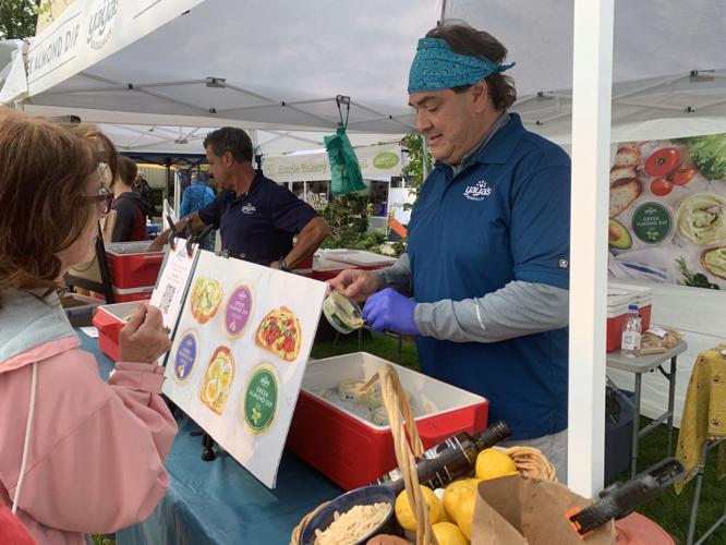 Michael Anagnos offers a sample of his Greek almond dip to a customer