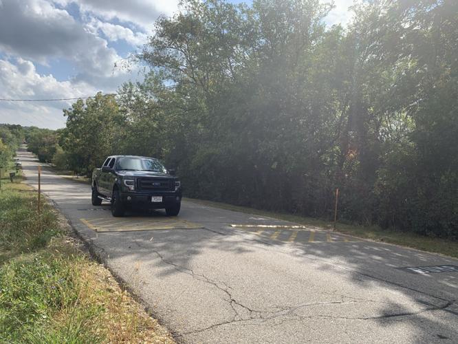 A vehicle drives over a speed bump on Center Street