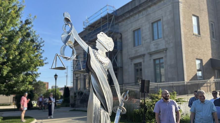 Martin Antaramian stands by unveiled sculpture