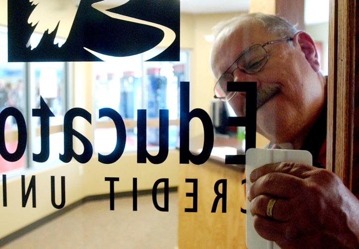Curt Pippenger smooths out the lettering on a door at the branch of Educators Credit Union at Bradford High School in Kenosha that opened in 2006
