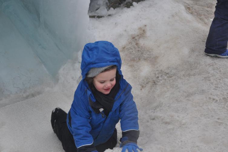 Remy Dickinson of Kenosha finishes his trip down an ice castle slide during the structure's final opening day