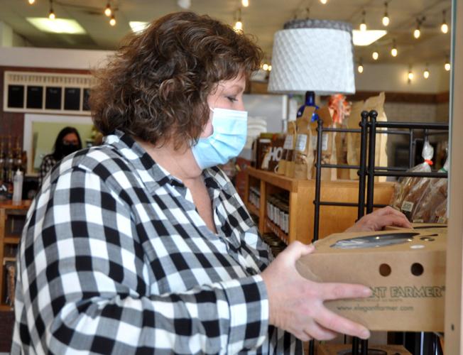 Roberta Robers, co-owner of The Farmstand, stocks some locally-produced pies on the shelf of the store
