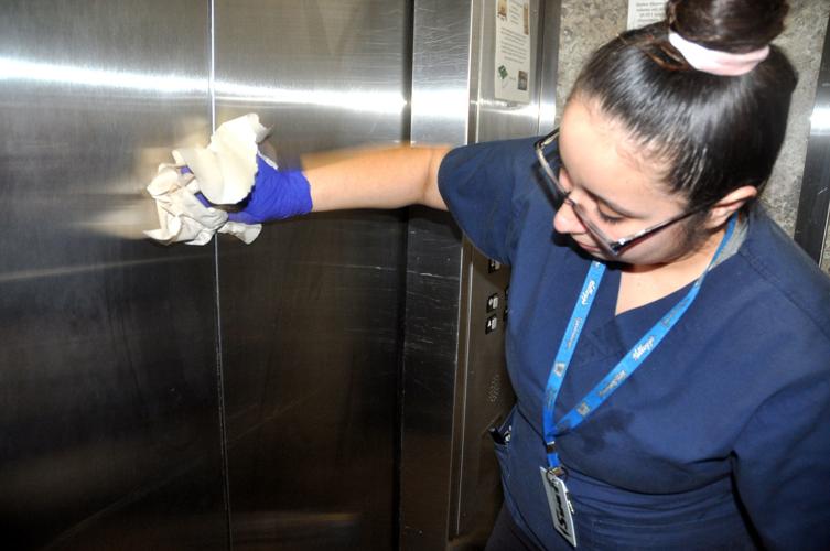 Vanessa Flores, Harbor Shores hotel employee, wipes down an elevator door