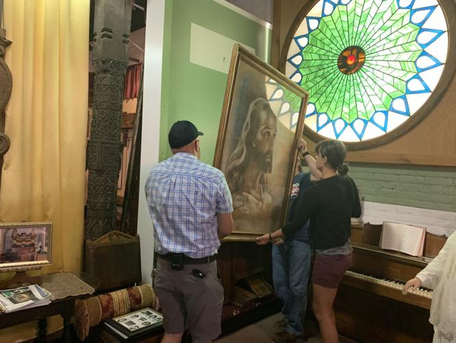 Representatives from Covenant Harbor Christian Camp and Geneva Lake Museum prepare to install a rendering of the "Head of Christ" painting