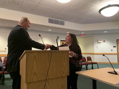 New Lake Geneva City Clerk Lacey Reynolds shakes City Attorney Dan Draper's hand after being sworn into her new position