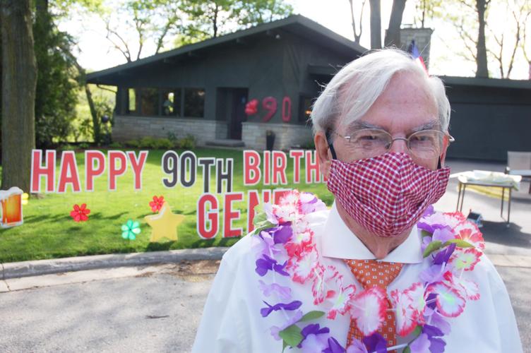 Gene Haseley in front of yard sign outside his home