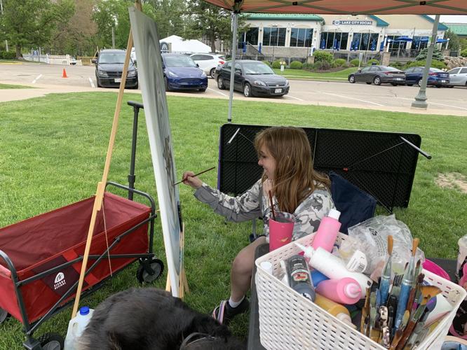 Kelly Lecander works on a painting in Flat Iron Park