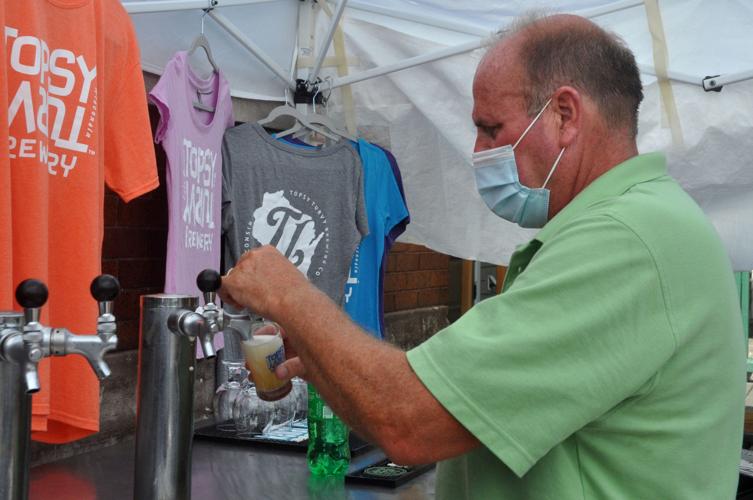 Terry Remke, Topsy Turvy Brewery sales manager, pours a beer for a customer