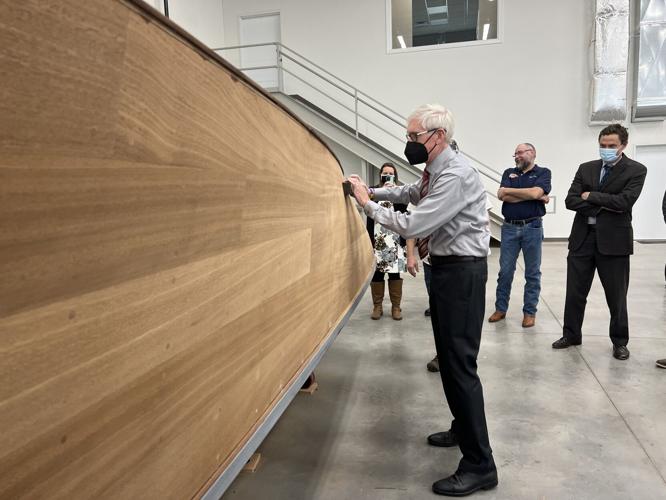 Gov. Tony Evers sands a custom-built mahogany boat at Grand Craft Boats in Genoa City in February 2022
