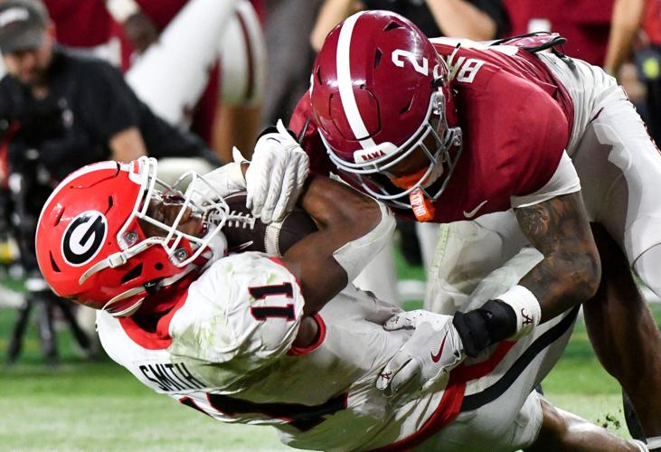 Sep 28, 2024; Tuscaloosa, Alabama, USA;  Georgia Bulldogs wide receiver Arian Smith (11) is tackled by Alabama Crimson Tide defensive back Zabien Brown (2) after a long reception to set up a touchdown at Bryant-Denny Stadium. Alabama defeated Georgia 41-34