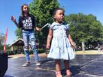 Sunshine Tidwell, 2, and Morgyn Oberlin, 11, dance on stage at Burlington Juneteenth