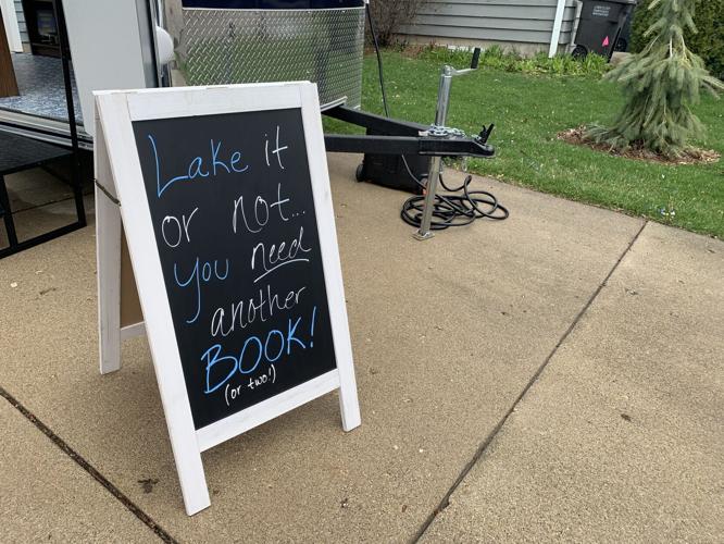 A sign stationed outside of Lakeside Books encourages people to purchase some reading materials