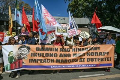 Protesters hold placards calling for the impeachment of Sara Duterte outside the House of Representatives in early February