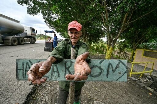 Cuban vendor Elio Galvan sells charcoal to families who have begun cooking over open fires amid ever longer blackouts caused by fuel shortages